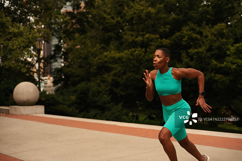 穿着运动服的女性在公园里跑步图片素材