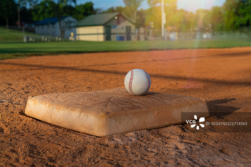 阳光照耀下的内场垒上的棒球图片素材