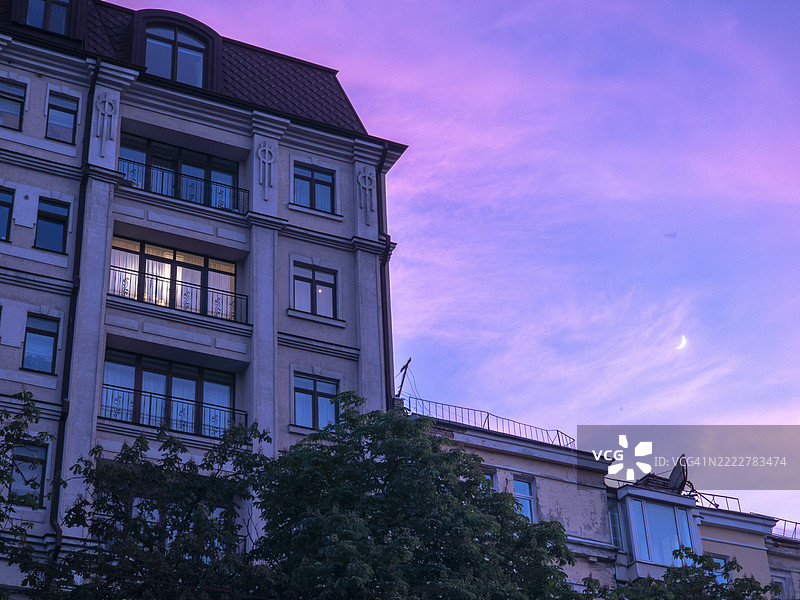 基辅黄昏的城市景观，紫色天空和弯月照亮历史建筑图片素材