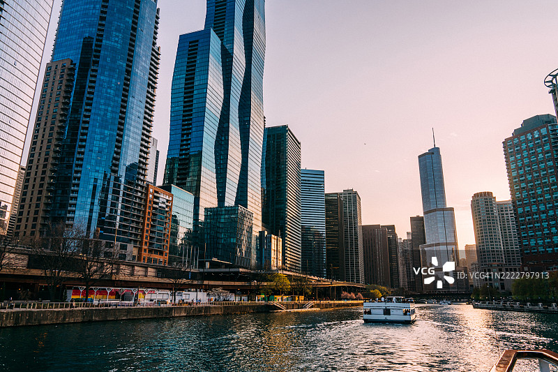 芝加哥，伊利诺伊州的天际线和日落时分的河船游览图片素材