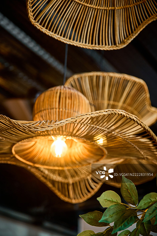手工编织的藤制吊灯，具有分层的灯罩。图片素材