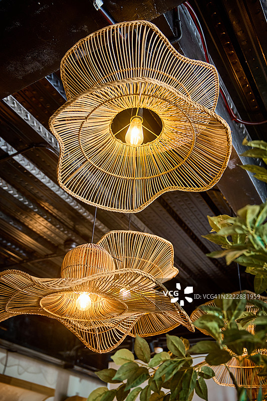 手工编织的藤制吊灯，具有分层的灯罩。图片素材
