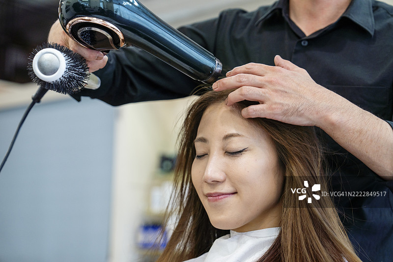 中年女性在美容院吹干头发图片素材
