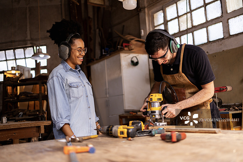 两个人在可持续木工车间合作。图片素材