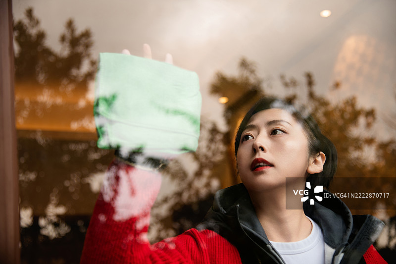 女人用抹布擦拭窗户玻璃图片素材