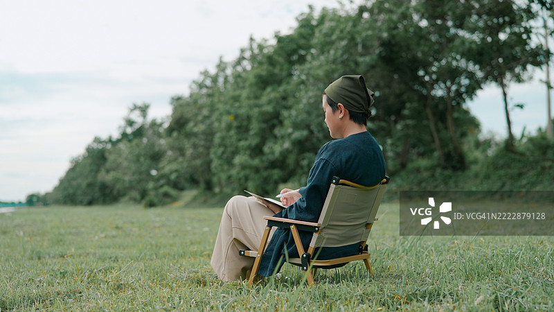 亚洲女性在公园里写笔记本图片素材