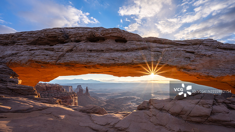 日出时，犹他州峡谷地国家公园的梅萨拱门后方的阳光照射图片素材