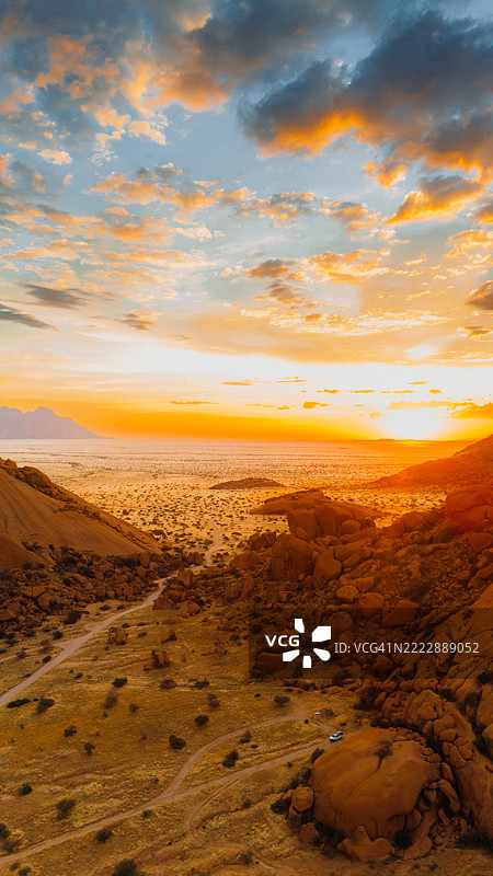 纳米比亚斯皮茨科普山悬崖上令人惊叹的日落空中视角，露营车营地图片素材