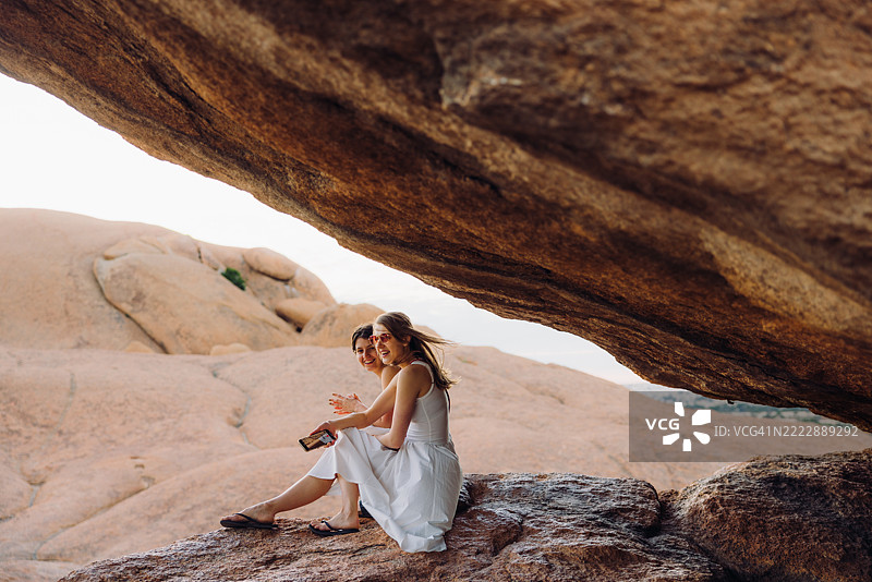 两个快乐的女孩在纳米比亚的壮丽斯皮茨科普山景观上欣赏日出图片素材