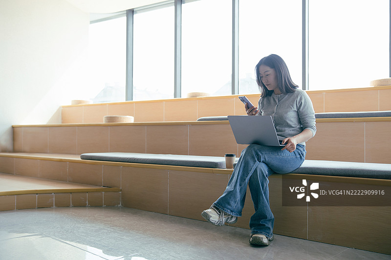 女商人在工作时查看智能手机图片素材