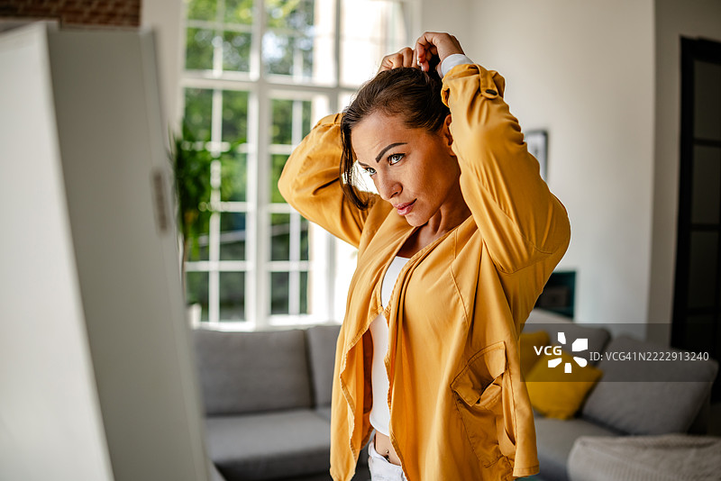 女人在镜子前打扮时看着自己图片素材