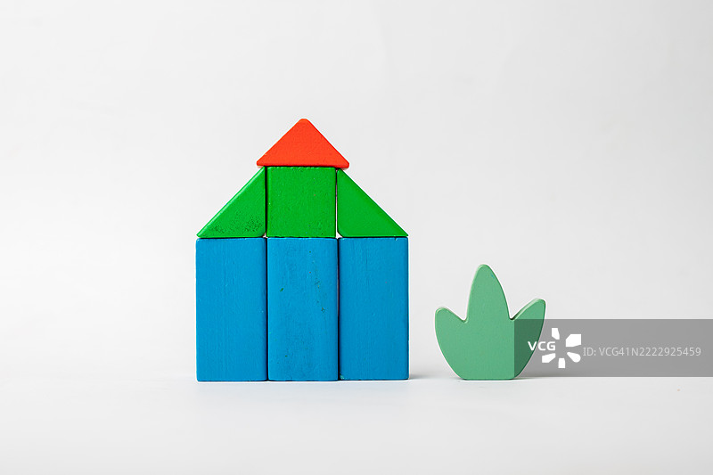 白色背景上的木制房屋积木与叶子图片素材
