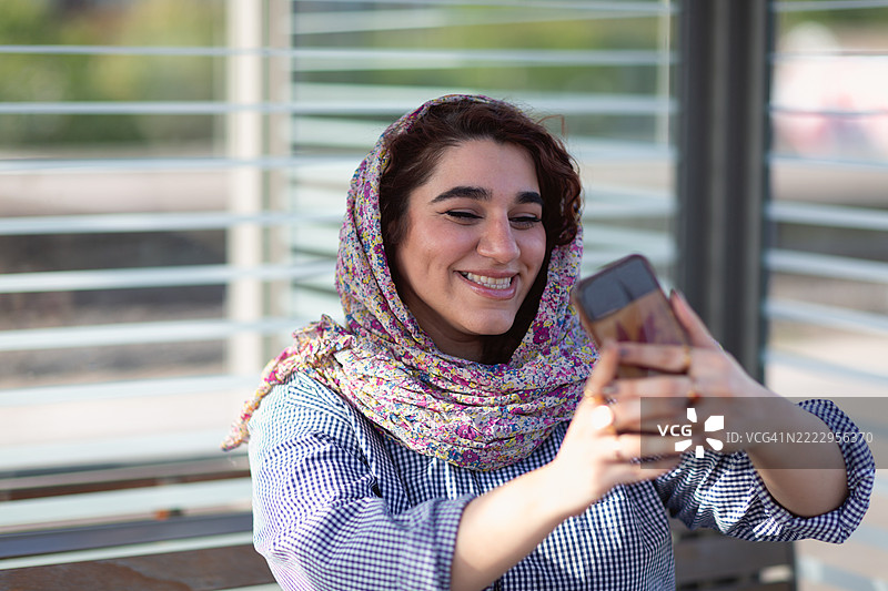 在火车站戴着头巾的年轻女性自拍图片素材