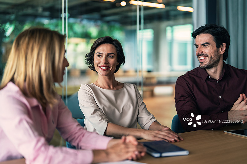办公室里的商务人士。商人和女商人在会议中讨论重要的财务文件。图片素材