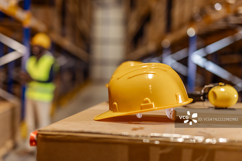 工业仓库环境中的黄色安全帽放在箱子上图片素材