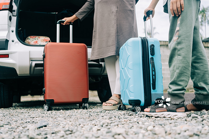 女人和儿子正在把行李装进车里的下半身部分图片素材
