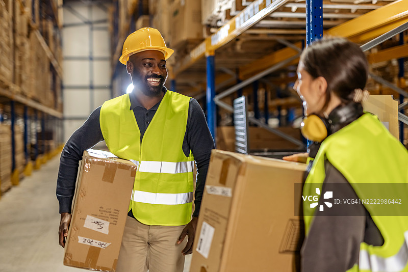 现代工业环境中，仓库工人与箱子协作图片素材