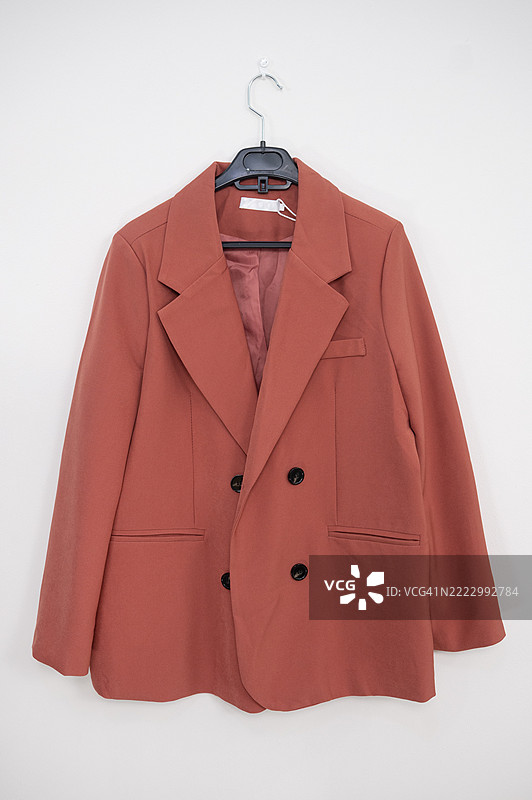 酒红色西装外套挂在衣架上图片素材