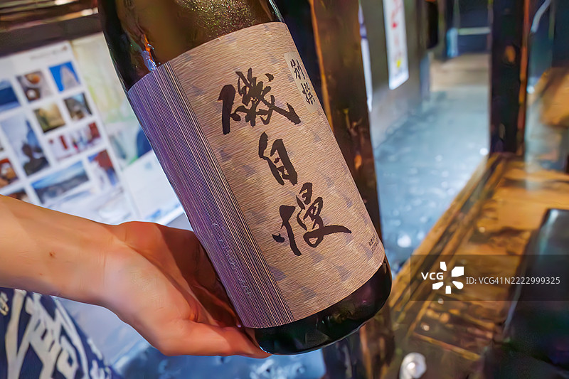 我们喝着来自静冈县的Isojiman大吟酿。酒杯、枡和盘子都装满了。图片素材