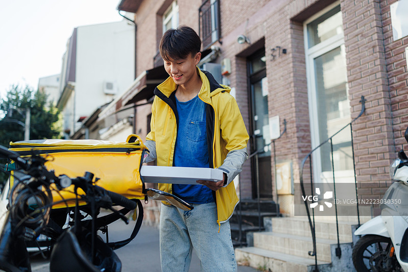 食品配送和快递服务 - 一名年轻的送货员在工作图片素材
