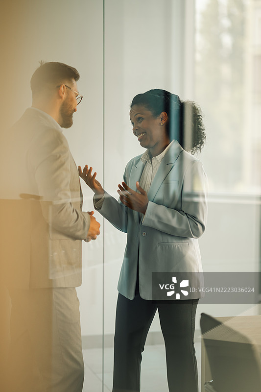 商务人士在办公室走廊交谈图片素材