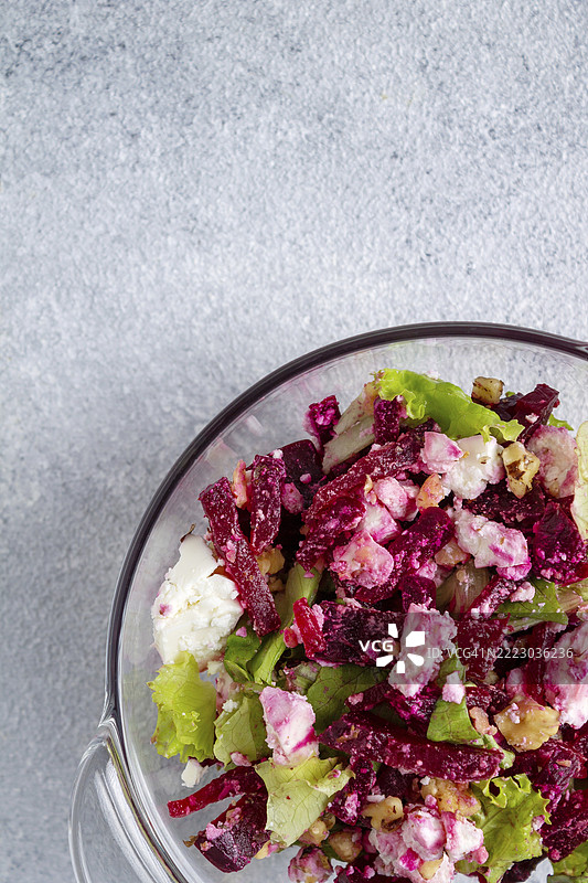 甜菜根沙拉，绿叶，奶酪，核桃放在玻璃盘中，留白空间图片素材