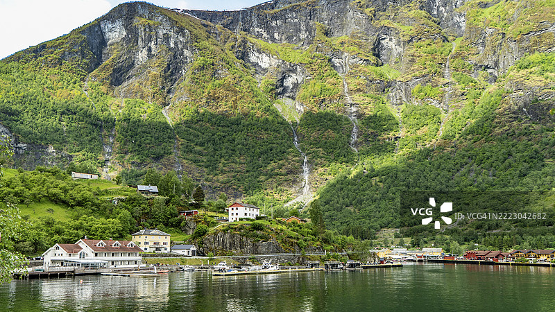弗拉姆村坐落在挪威峡湾的高耸山脉下图片素材