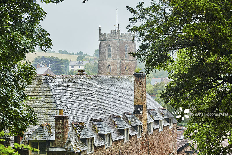 英格兰,米奈德,埃克斯穆尔,邓斯特村的教堂塔楼,周围环绕着树木和乡村。邓斯特村和邓斯特城堡,英国,欧洲图片素材
