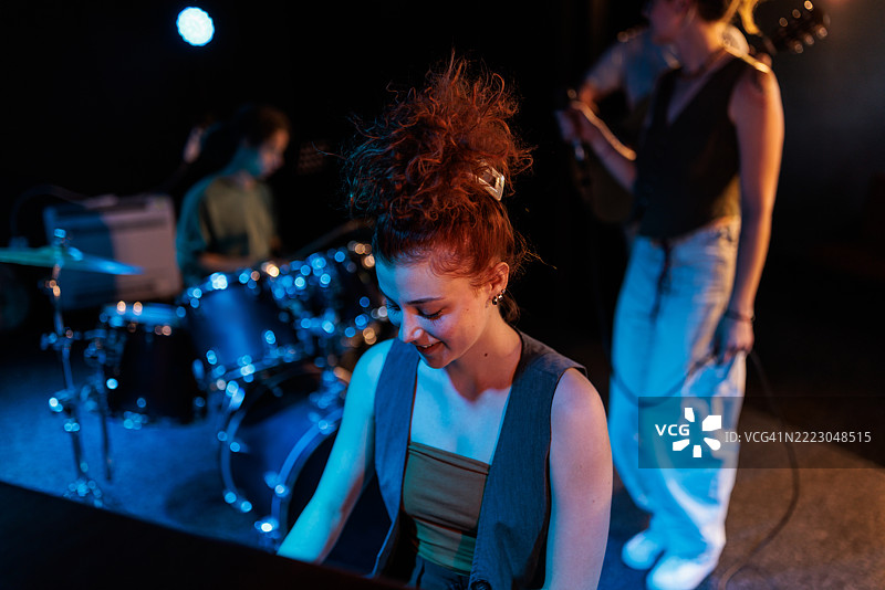 光彩照人的钢琴家在现场乐队表演中熠熠生辉图片素材