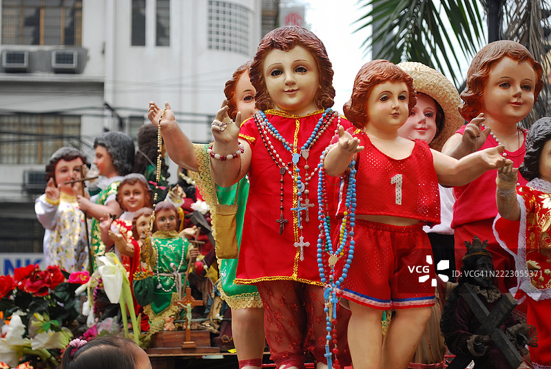 色彩斑斓的圣婴雕像街头展示，身着华丽服饰。图片素材