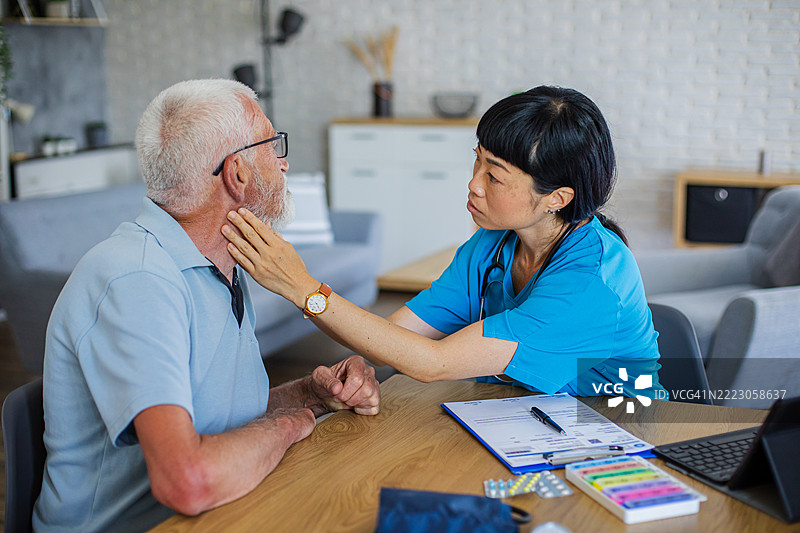 医疗工作者在家中为老年患者进行身体检查图片素材