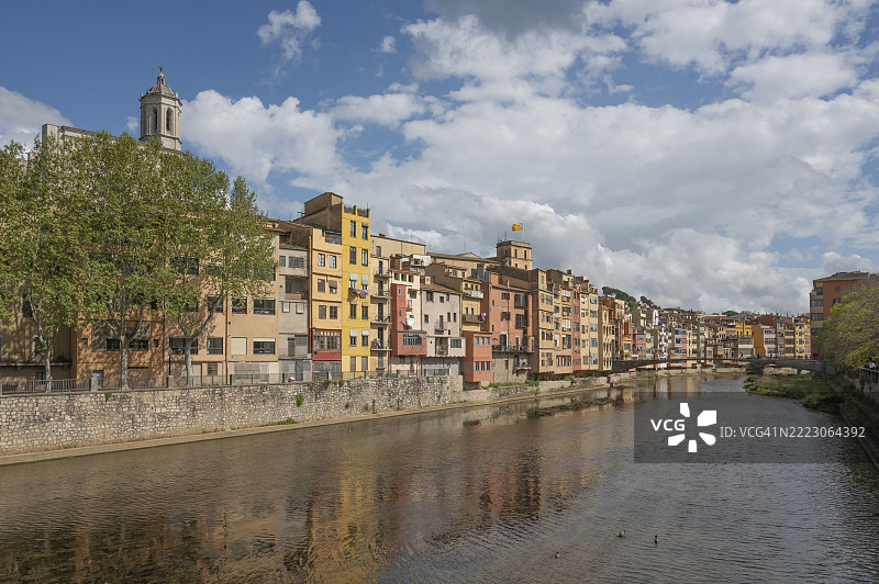 大教堂的八角塔高耸于河畔老房子的色彩斑斓的外立面之上，河流Onyar上架着Pont d'en Gómez o de la Princesa桥，西班牙加泰罗尼亚，赫罗纳，欧洲。图片素材