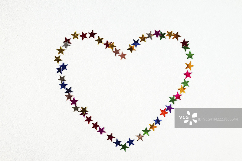 白色背景上心形排列的五彩纸屑，留白空间图片素材