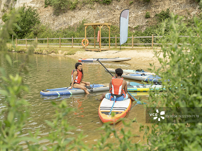 朋友们在湖上放松地划着立式划水板图片素材