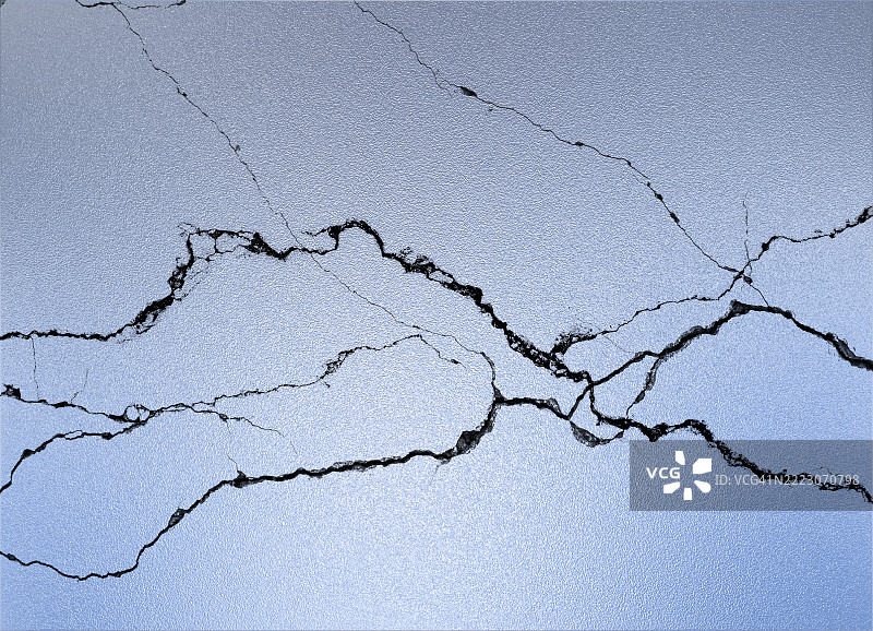 墙壁上涂有闪亮银蓝色的裂缝。图片素材