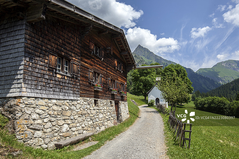 德国巴伐利亚州奥伯阿尔戈伊地区奥伯斯多夫附近的迪特斯巴赫谷，马里恩教堂和霍法茨后面的历史山地农业村格尔斯特鲁本的老农舍图片素材