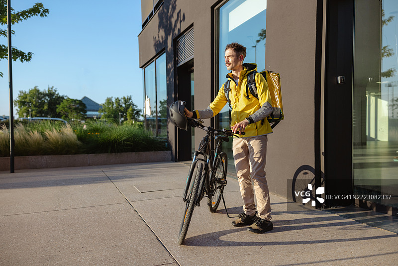 骑自行车的快递员，背着保温热袋图片素材