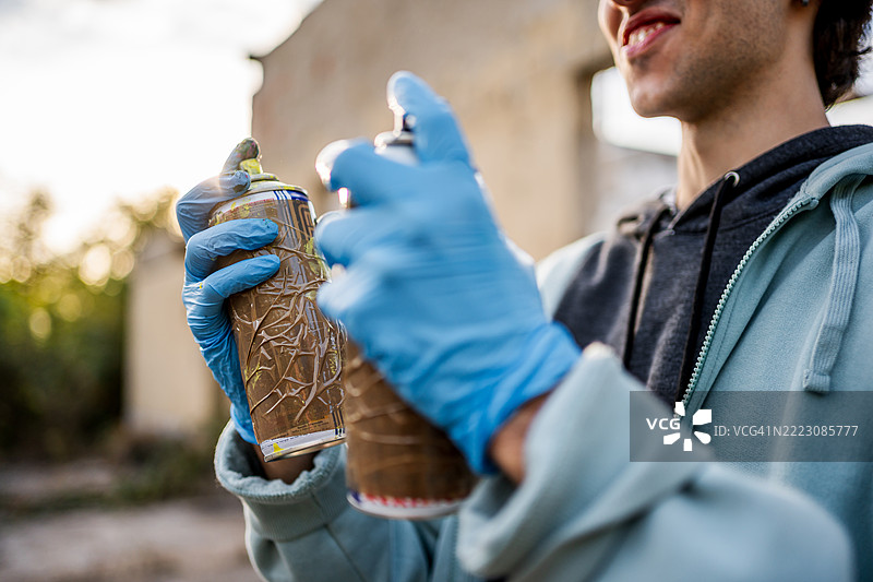 街头艺术家正在准备喷漆罐以进行涂鸦艺术图片素材