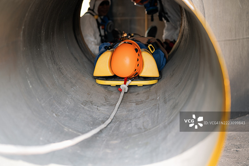 高级培训以协助管道灾难受害者，模拟使用绞盘和绳索提升和救援无法自救的伤者，符合密闭空间救援和绳索救援的概念。图片素材