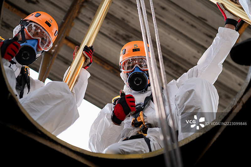 高级培训以协助管道灾难受害者，模拟使用绞盘和绳索提升和救援无法自救的受害者，符合密闭空间救援和绳索救援的概念。图片素材