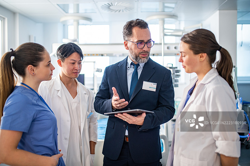 制药公司销售员与医生交谈，展示新医疗技术。图片素材