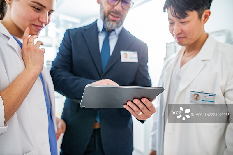 制药公司销售员与医生交谈，展示新医疗技术。图片素材