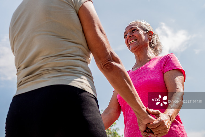 户外与朋友交谈的老年女性图片素材