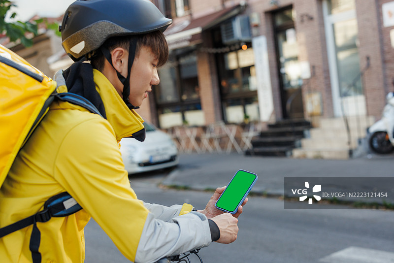 外卖员在城市路线中户外查看手机图片素材