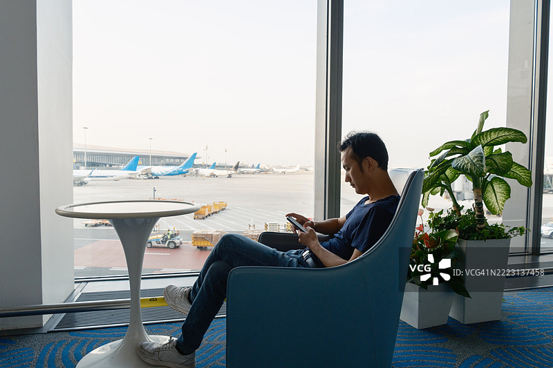 亚洲男子在机场等待航班图片素材