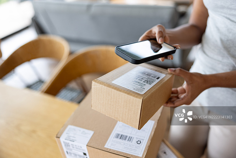 女性在家使用手机应用程序进行包裹直销图片素材