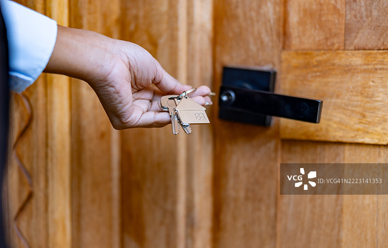 房地产经纪人用钥匙打开她的房子的门图片素材