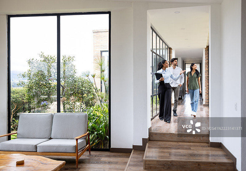 房地产经纪人向一对夫妇展示一栋美丽的现代房屋图片素材