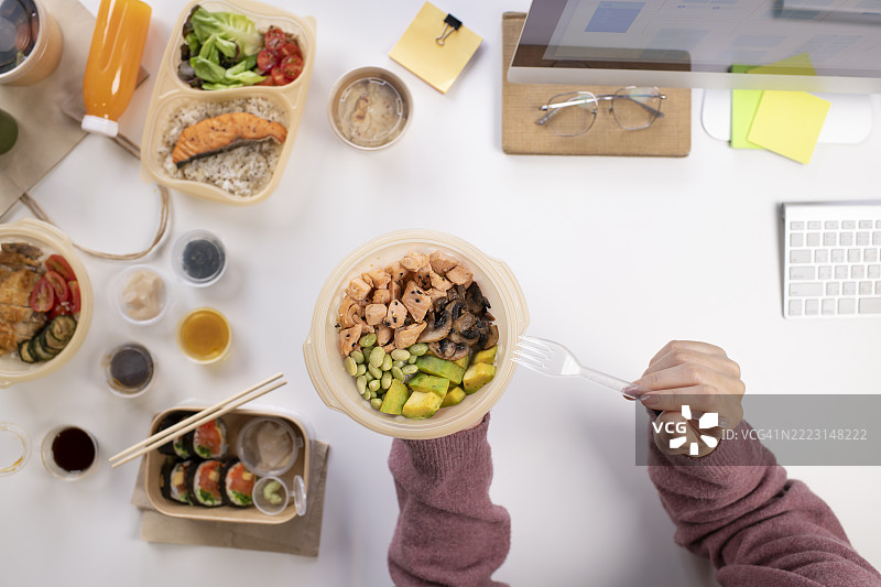 亚洲女性在工作时享用健康餐，俯视图图片素材