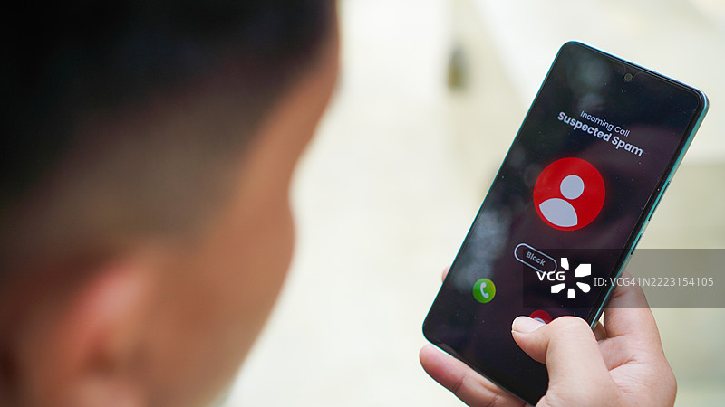 男子在智能手机上接到来自未知来电者的可疑电话并拒接该电话图片素材